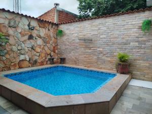 a swimming pool in front of a brick wall at Cantinho Abençoado in Pirenópolis
