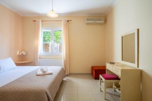 a bedroom with a bed and a desk and a television at Casa Carina in Lakíthra