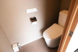 a bathroom with a toilet and a toilet paper dispenser at Lake Side Inn MIRAHAKONE in Hakone +14 photos