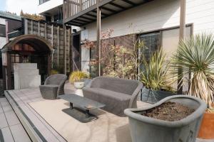 a patio with two chairs and a table and a bench at Lake Side Inn MIRAHAKONE in Hakone