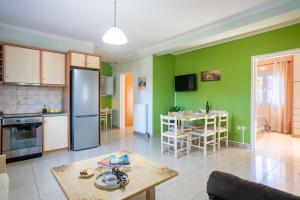 a kitchen and dining room with green walls and a table at Casa Carina in Lakíthra +18 photos
