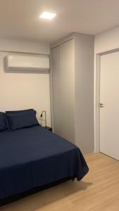 a bedroom with a blue bed and a sliding door at SeuLoft 110SouMais in Niterói +9 photos