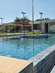 a swimming pool with blue water in front of a building at SeuLoft 110SouMais in Niterói