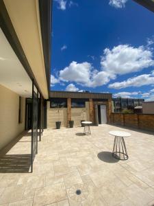 a patio with two tables on top of a building at Belmore Living in Goulburn