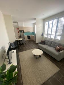 a living room with a couch and a table at Belmore Living in Goulburn