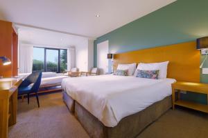 ein Hotelzimmer mit einem großen Bett und einem Schreibtisch in der Unterkunft Nightelier Devonport Gateway Hotel in Devonport + 64 Fotos