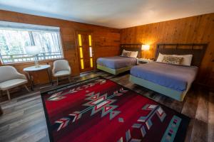 a bedroom with two beds and a red rug at The Tamarack Lodge in Lakeshore