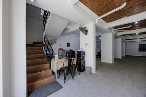 a room with stairs and a table and chairs at Urbanview TeBeYe Syariah UNS Solo in Solo