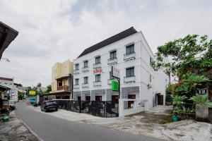 a white building on the side of a street at Urbanview TeBeYe Syariah UNS Solo in Solo
