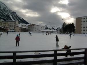Eine Gruppe von Menschen, die auf einer Eisbahn Schlittschuh laufen in der Unterkunft Mountain Studio, Lenzerheide in Lenzerheide