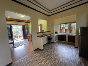 a large kitchen with wooden floors and a counter top at Srisook House in Ko Phangan