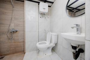 a bathroom with a toilet and a sink at Urbanview TeBeYe Syariah UNS Solo in Solo +16 photos