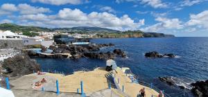 a set of stairs leading to the water with people at Charme do Largo - Apartment in Lagoa