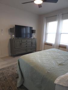 a bedroom with a bed and a flat screen tv at Twin Nest Duplex in Irving