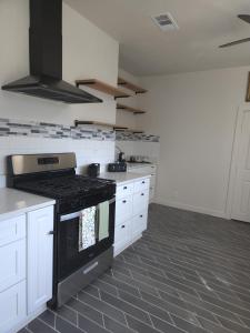 a kitchen with white cabinets and a black stove at Twin Nest Duplex in Irving +16 photos