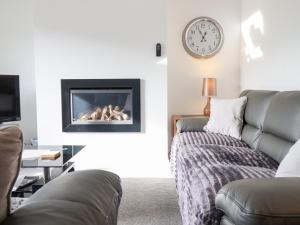 a living room with a couch and a fireplace at Arnant in Dolgellau
