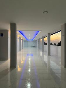 an empty hallway with blue lights in a building at Serenity House in Santa Marta