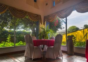a dining room with a table and chairs in front of a window at Hotel Savoy Inn in Quito