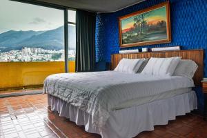 a bedroom with a bed and a large window at Hotel Savoy Inn in Quito
