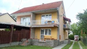 a yellow house with a balcony and a fence at Studios near Beach in Balatonfoeldvar 18525 in Balatonföldvár
