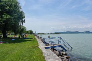a blue bench next to a body of water at Studios near Beach in Balatonfoeldvar 18525 in Balatonföldvár +11 photos