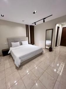a bedroom with a large white bed and a mirror at Duplex villa in Beverly Hills in Sheikh Zayed