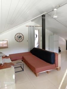 a living room with a couch and a clock on the wall at Loft haut de villa in Baie-Mahault