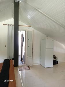an empty room with a refrigerator and a door at Loft haut de villa in Baie-Mahault