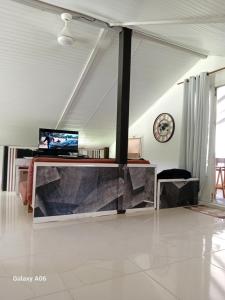 a living room with a television on a table at Loft haut de villa in Baie-Mahault