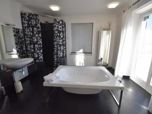 a bathroom with a large tub and a sink at Villa with Panoramic Views for 6 in Oggebbio +32 photos