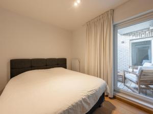 a bedroom with a bed and a large window at Knokke City Centre Apartment for 6 in Knokke-Heist