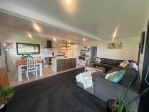 a living room with a couch and a kitchen at TAT's Place in Coopers Beach
