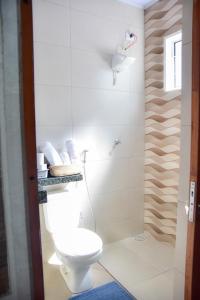 a white bathroom with a toilet and a shower at Pousada Paraiso valle verde in Estivado +62 photos