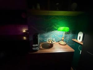 a green lamp sitting on a table in a room at Le 1920- Spa & Sauna privé- Love Room in Le Havre +2 photos