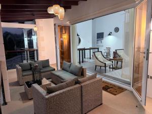 a living room with couches and chairs and a table at The House Next Door in Calliaqua