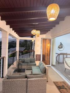 a patio with couches and chairs on a balcony at The House Next Door in Calliaqua