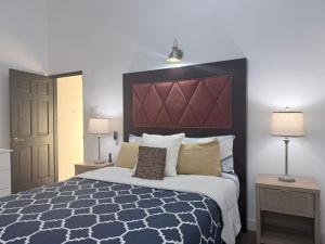 a bedroom with a large bed and two lamps at The House Next Door in Calliaqua