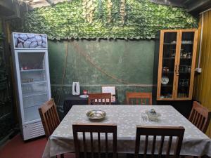 a dining room with a table and chairs and a green wall at Hostel INK - Duerme Como En Casa in Concepción