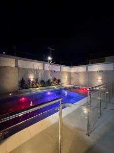 a swimming pool at night with blue and red lights at Serenity House in Santa Marta