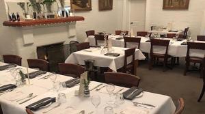 a room with tables and chairs with white tablecloths at white hart hotel murrurundi in Murrurundi