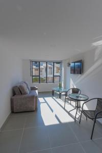 a living room with a couch and a table and chairs at Denier House Fuente de los Rosales - A 5 minutos de Centros Comerciales in Ibagué