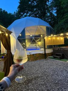 a person holding a glass of wine in front of a tent at Luna Glamping in Pigeon Forge