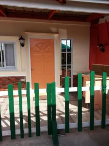 a green fence in front of a house at Vhauschild Transient Rooms in Alaminos