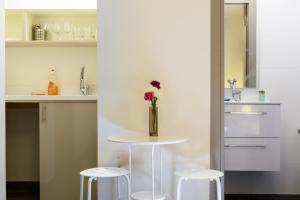 een keuken met een tafel met een vaas met bloemen erop bij Dizengoff Inn Apartments in Tel Aviv