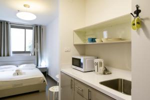 una camera con letto, lavandino e forno a microonde di Dizengoff Inn Apartments a Tel Aviv