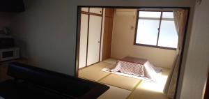 a mirror in a room with a bed and a window at 桜庵 sakura an in Hatsukaichi