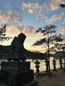 a statue of a lion in front of a body of water at 桜庵 sakura an in Hatsukaichi
