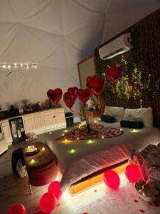 a bedroom with a bed with red hearts on the wall at Skye Glamping in Pigeon Forge +68 photos