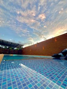 a large blue swimming pool with a brick wall at Espectacular Casa Quinta in Girardot
