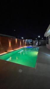 a swimming pool at night with green illumination at Espectacular Casa Quinta in Girardot +1 photo